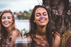 Two friends wearing purple and blue Nözscreen environmentally friendly sunscreen 